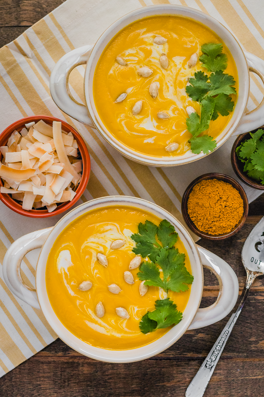 vegan creamy curried butternut squash soup garnished with roasted seeds and cilantro