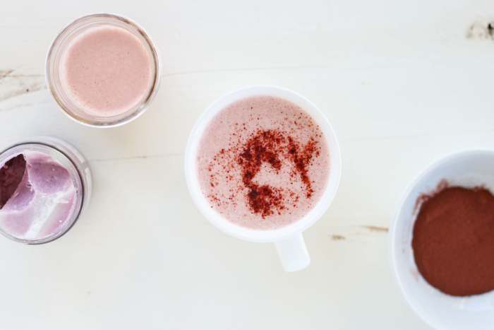 a pretty pink beetroot latte in a white cup sprinkled with beetroot powder