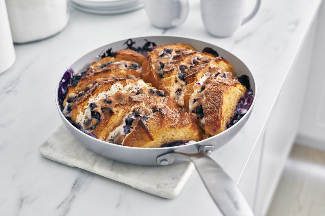 Image of an oven-safe pan with freshly baked sweet bread used in a greenpan review. The pan has a brushed steel handle and sits on a marble square on a marble countertop.