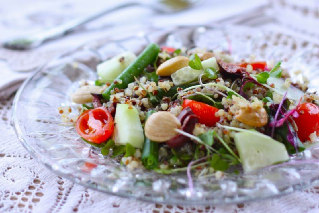 Image of a fresh Mediterranean quinoa salad with grape tomatoes, fresh green beans, and cucumber showing one way to cook fresh green beans.
