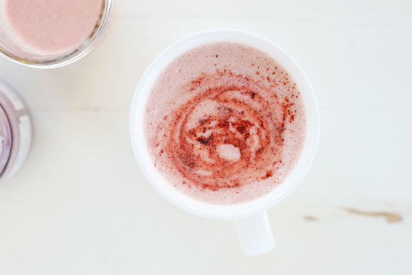 a pretty pink beetroot latte in a white cup sprinkled with beetroot powder