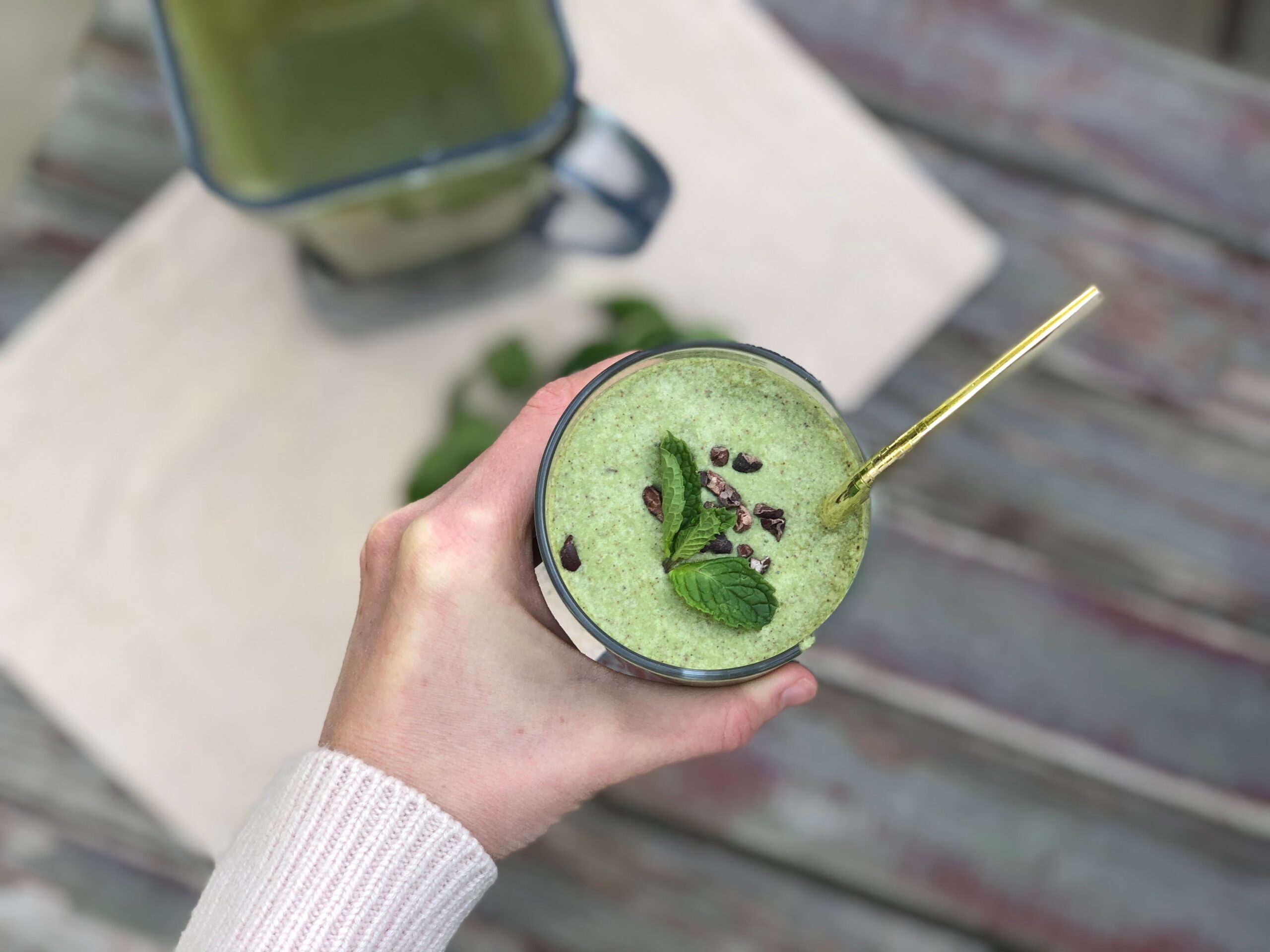 Image of a female hand holding a healthy chocolate milkshake with cocoa nibs and mint. Make this with vanilla ice cream if you really want to punch up the minty flavors or make it with chocolate ice cream and even add a teaspoon of cocoa powder to punch up the chocolate (and antioxidants!). If you're a total chocoholic, you could always add an organic chocolate sauce or chocolate syrup drizzle.