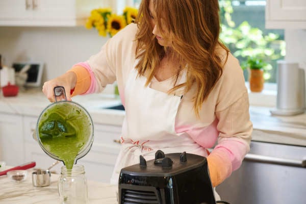 Image of Laura Klein pouring mint chocolate green smoothie with collagen. This chocolate milkshake is not only super delicious (like actually) it's also packed with superfoods that make it super healthy for an all around super chocolate milkshake recipe. It would be great made with plant-based chocolate ice cream as well to bump up the chocolately goodness or vanilla ice cream and topped with whipped cream and chocolate syrup if you want to go all the way dessert milkshake vibes.