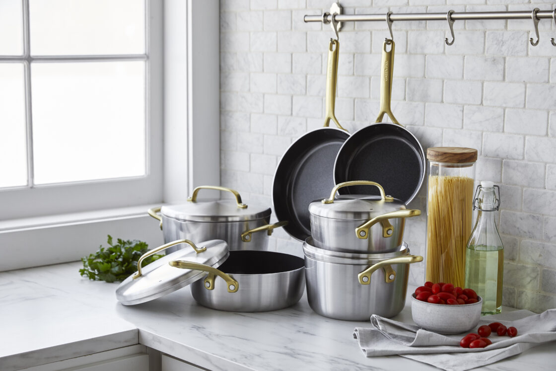 Image of one of our favorite cookware sets, the GP5 Stainless which sits stacked on a modern marble counter with a marble subway tile backsplash. You can invert the lids, which is helpful for stacking the pieces.