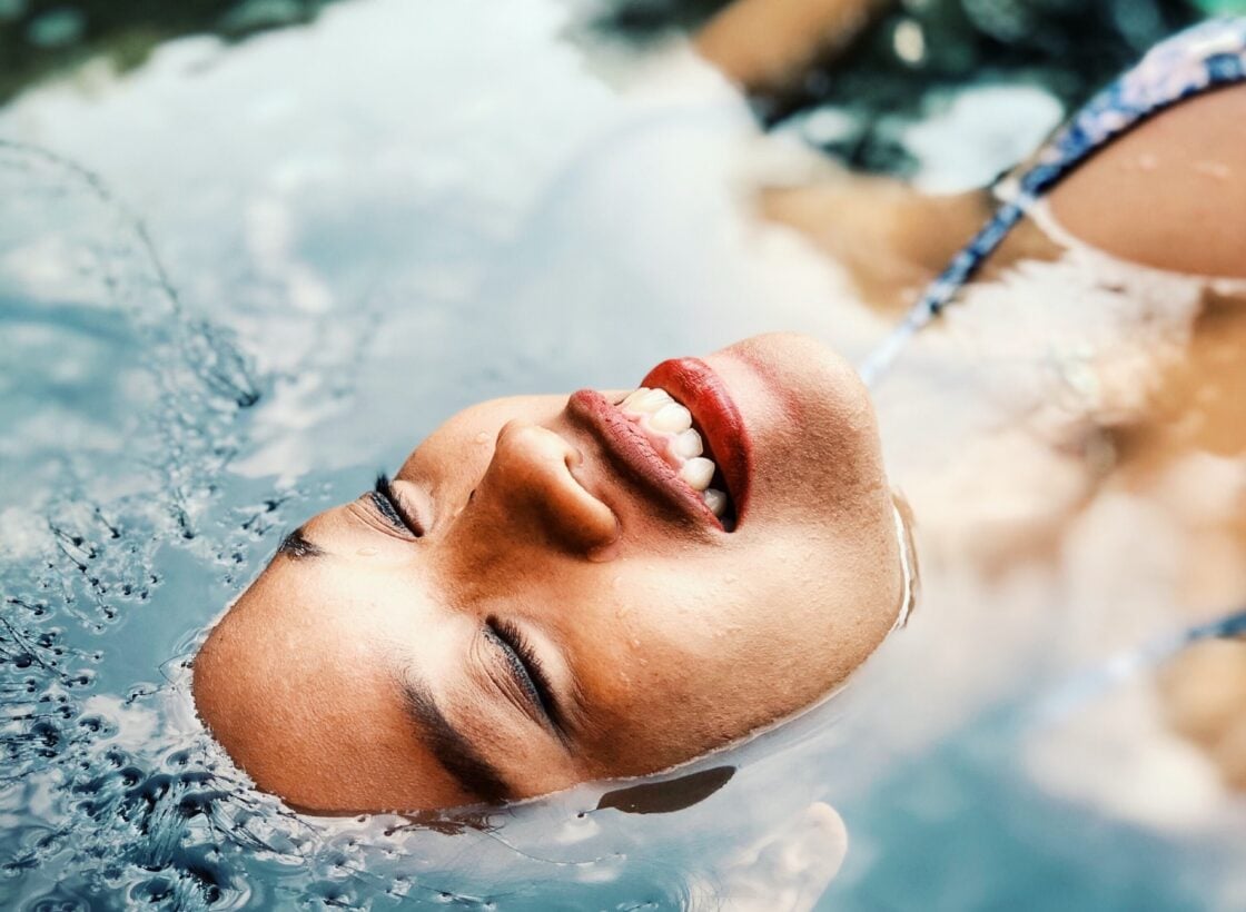 image of Woman in water smile. Apple cider vinegar may support skin health.