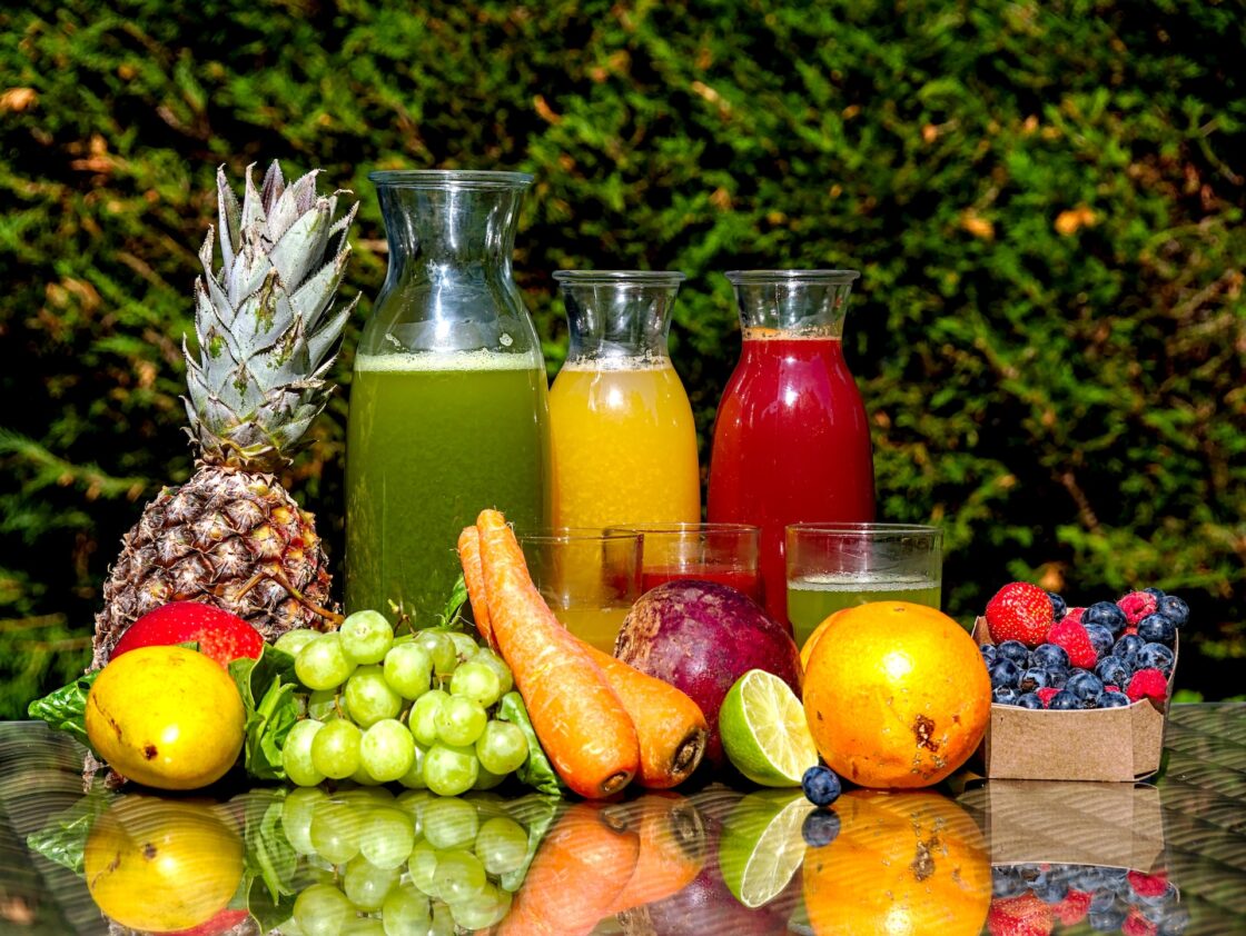 Image of juices and fruits and vegetables on a table outside supporting vegan collagen production