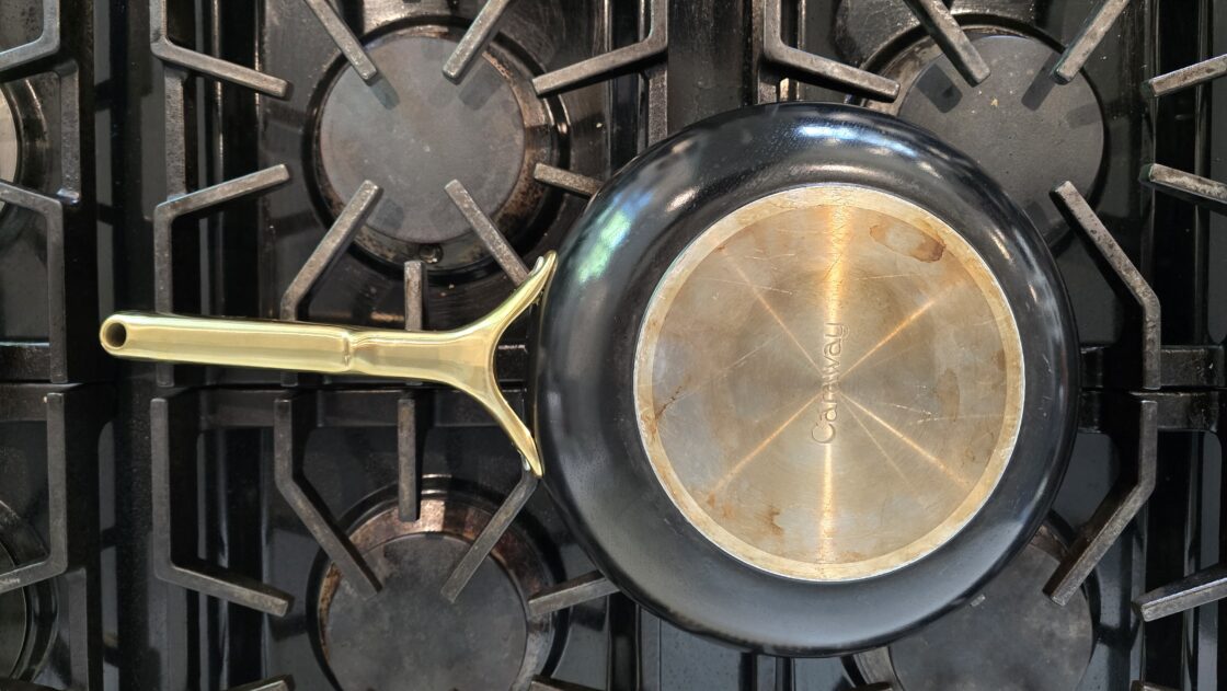 Image of the bottom of a Caraway nonstick pan that is a little discolored from years of testing and reviewing for a caraway pot and pan review