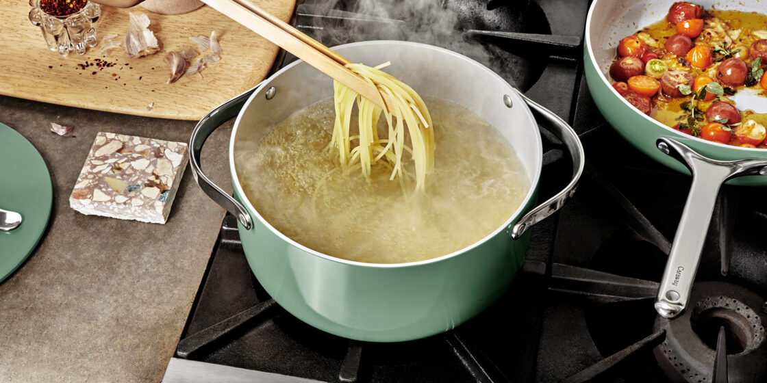 Image of a Caraway naturally nonstick dutch oven with pasta cooking on a stove for a caraway home reviews