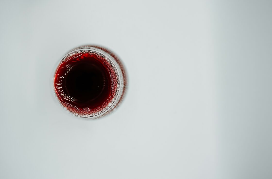 Image of an overhead view of a glass of red wine healthy for your heart, or is it? What does science and research point to?