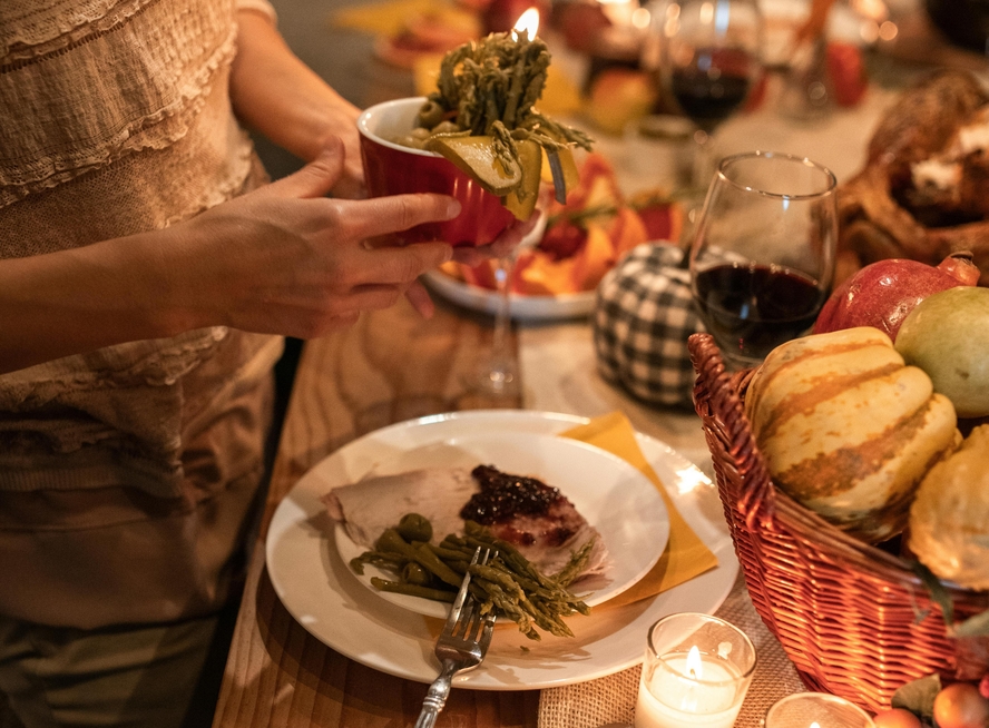 Image of a Thanksgiving table with a plate with turkey and cranberry sauce leftovers.