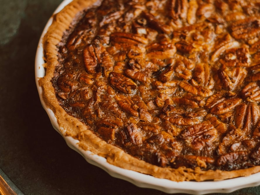 Image a full pecan pie in a circular baking dish.