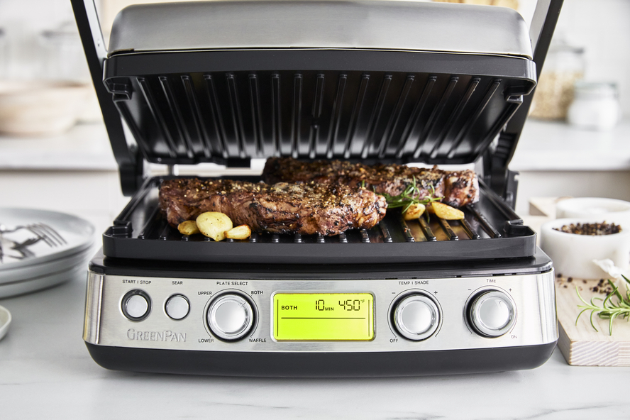 The GreenPan Multi Grill, Griddle & Waffle Maker cooking a steak and garlic with the grill function.