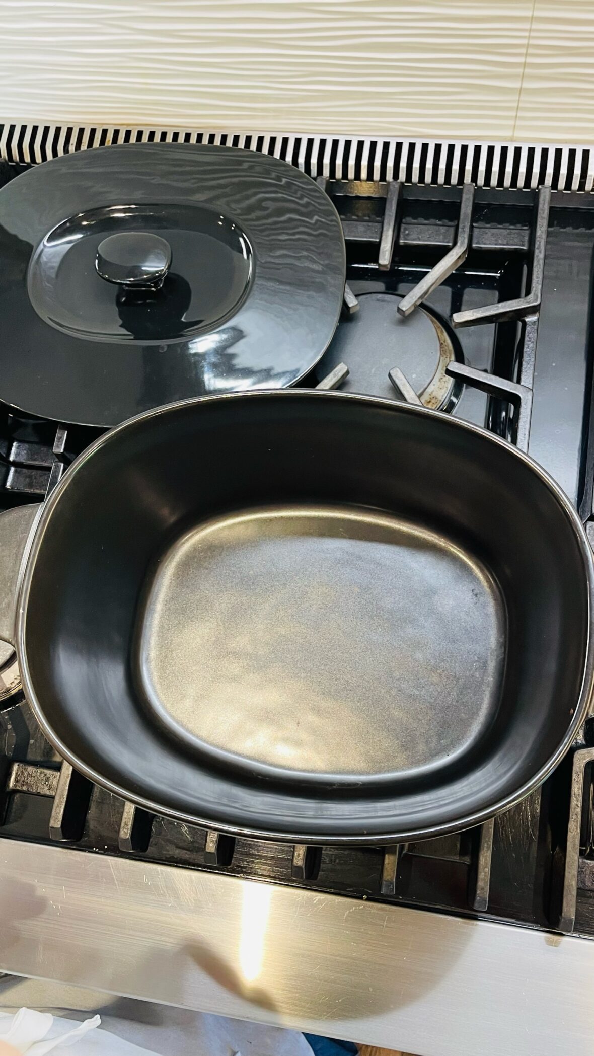 image of large, oval, black pure ceramic Dutch oven by Xtrema, open and empty on a gas range.