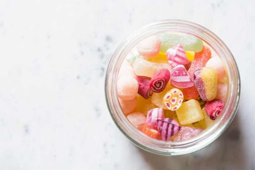 What are sugar alcohols in food? An image of sugar-free candies in a clear bowl on a marble table.