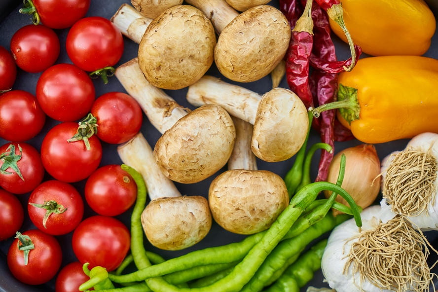 Image of an assortment of vegetables, from tomatoes to green beans, mushrooms, peppers, and chillies.