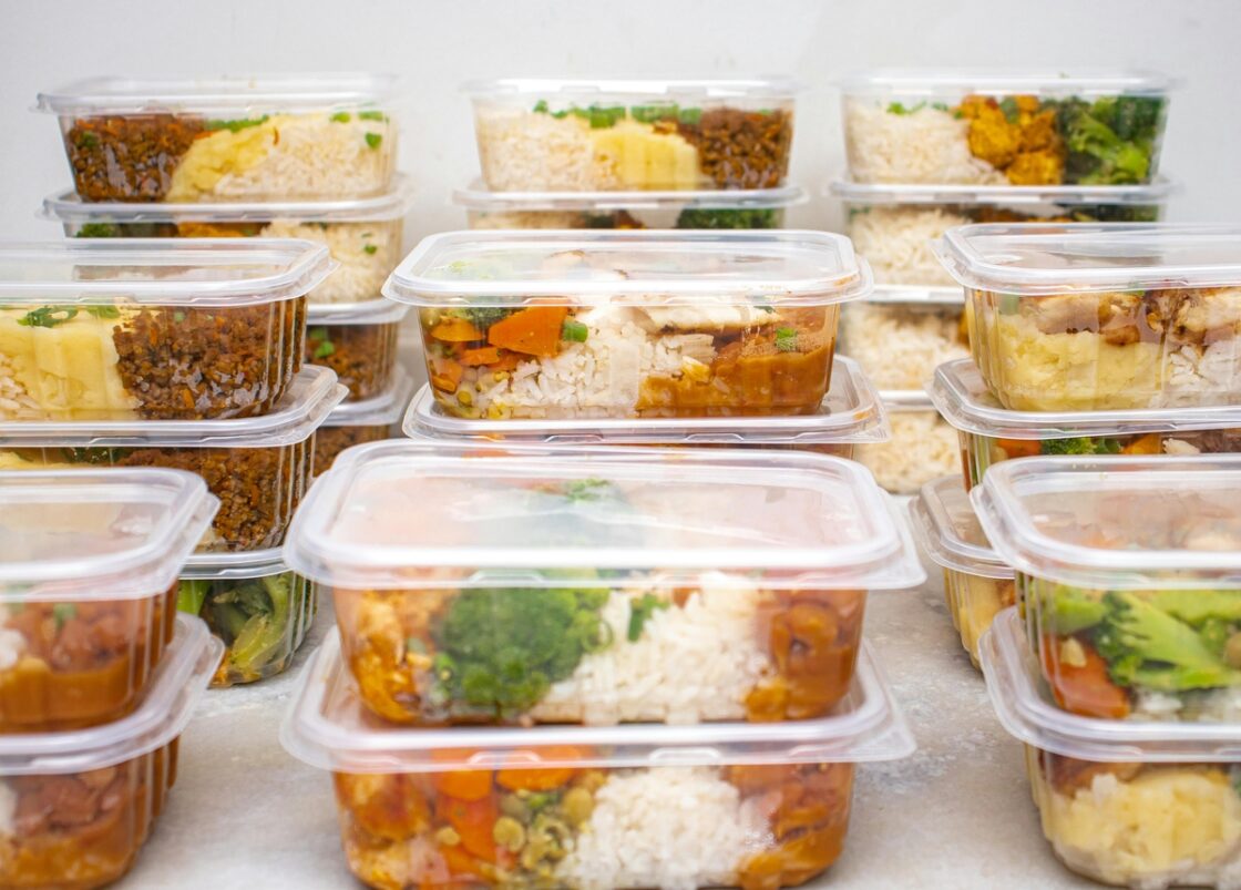 Image of stacks of healthy meals prepped for the week, stored and stacked in plastic containers.